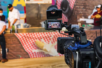 A cameraman makes footage and broadcasts a cooking show on tv