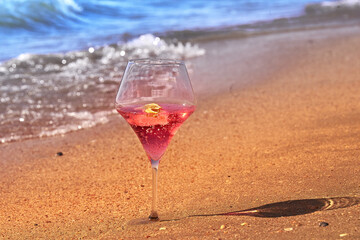 Wine glass with a cocktail by the sea.