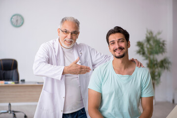 Obraz premium Young male patient visiting old male doctor