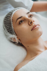 Close-up portrait of a woman during facial massage in spa salon. Facial treatment. Beauty skin care. Beauty skin female face.
