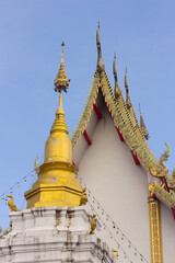 Thai golden pagoda and chapel with blue sky