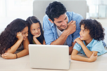 Exploring online together. Shot of a smiling family lying on the floor and surfing the internet.