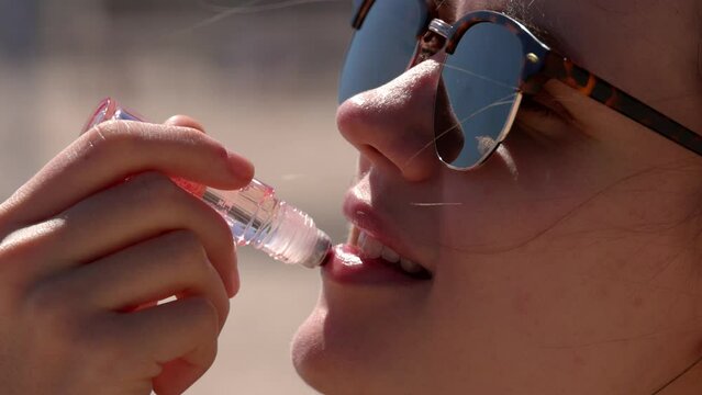 Young woman applies Lip gloss - close up shot - travel photography