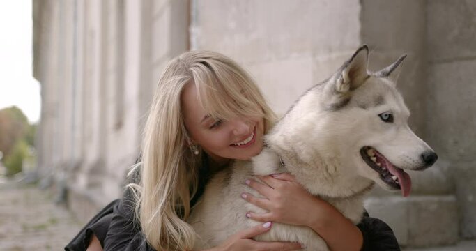 Happy young woman hugging her dog outdoors