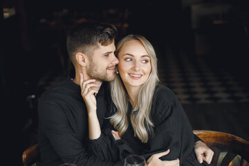 Couple hugging and have wine in cafe