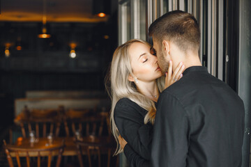Romantic young couple hugging at cafe window