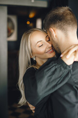 Romantic young couple hugging at cafe window