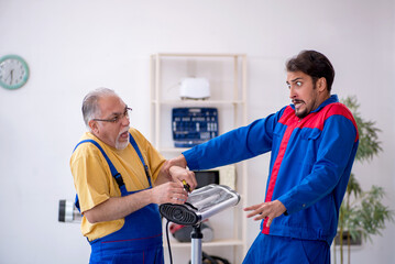 Two male repairmen working at workshop