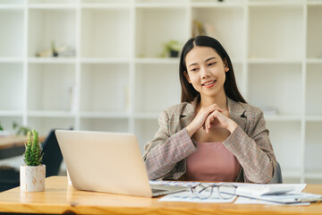 Charming asian businesswoman sitting working on laptop in office.