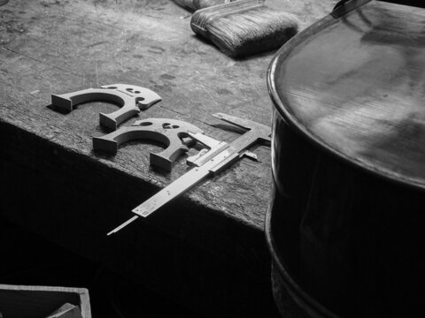 senior luthier in his workshop choosing bridges for a cello - Powered by Adobe