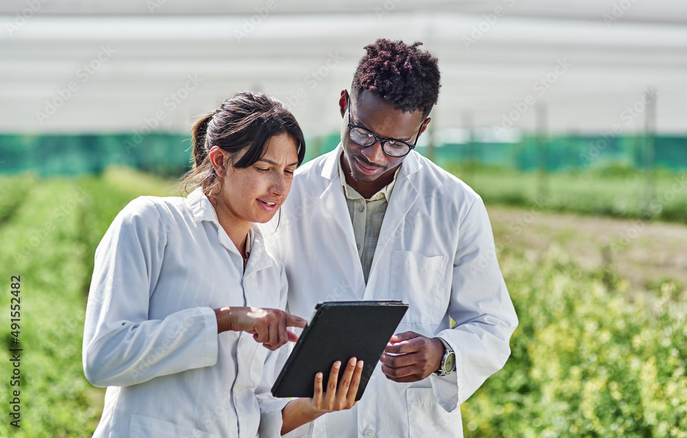 Aufkleber look at what i discovered earlier. shot of two young scientists using a digital tablet wile studying