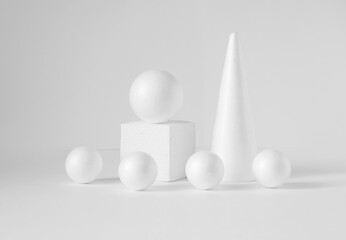 Monochrome composition of various 3d geometric shapes. White balls of different sizes, cube, cone, on an isolated background. Concept of podiums for product presentations