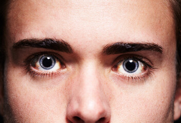 High as a kite. Closeup portrait of a young mans face with dilated pupils. - obrazy, fototapety, plakaty
