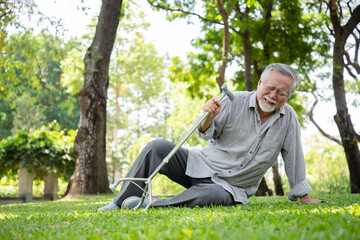 Naklejka na ściany i meble An elderly man walks and accidents while exercising in his backyard. He injured his ankle and was unable to stand up. Senior healthy and insurance concept