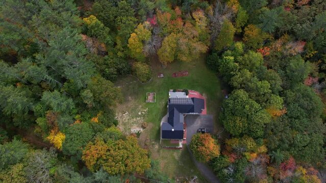 Birdseye Aerial View of Hidden House in Colorful Forest in American Countryside. New Hampshire USA, Drone Shot