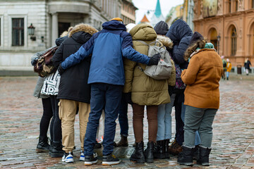 A flock of young people together in a circle in the city square