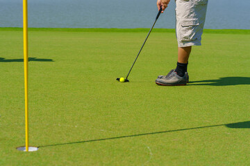Obraz premium Golfer preparing for a putt Golf ball on the green during golfcourse