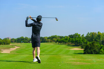 Man Golfer Hitting Ball with Club on Beatuiful Golf Course