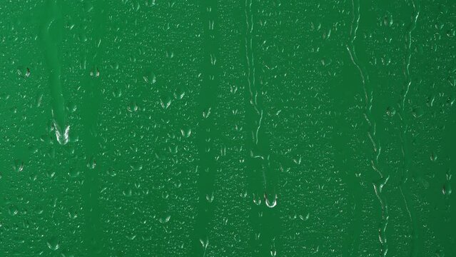 Water rainfall, rain drops falling on window glass over chroma key green screen