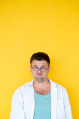 Displeased man. Dissatisfied feelings. Protesting look. Skeptic grimacing guy in white shirt feeling disgust emotion isolated yellow.