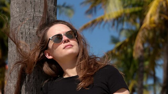 Young woman relaxes at the promenade of Miami Beach on a sunny day - travel photography