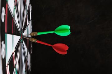 Two darts are stuck in the center of dartboard.Achieving goals in business and in life.