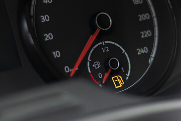 soft focus. natural light. the dashboard. it is lit, the fuel level arrow shows that it is empty, refueling is necessary. there is a tinting.