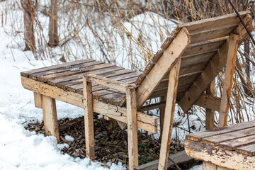 Wooden bench on the snow in the park.