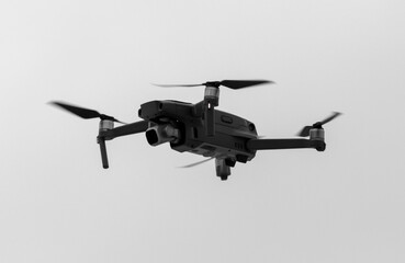 Drone in flight against a cloudy sky.