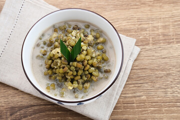 Mung Bean Porridge or Bubur Kacang Hijau, Indonesian dessert porridge of mung beans with coconut milk, pandan leaf and ginger. Served in bowl.
