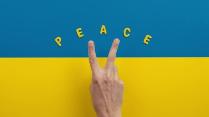 Victory and peace with hand making symbol on the flag of Ukraine
