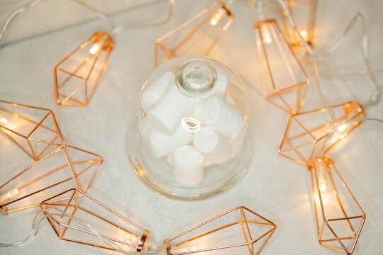 marshmallows in a glass bowl against the background of a luminous garland