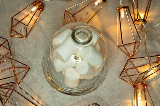 marshmallows in a glass bowl against the background of a luminous garland