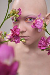 A beautiful woman without hair with flowers on her head, a conceptual photo with an unusual model
