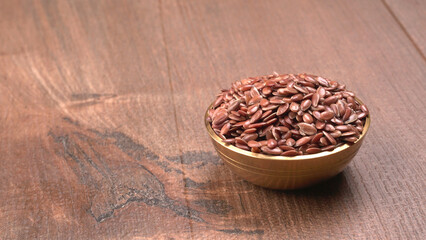 Brown flax seed or linseed on wooden background. Diet healthcare healthy food.
