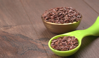 Brown flax seed or linseed on wooden background. Diet healthcare healthy food.
