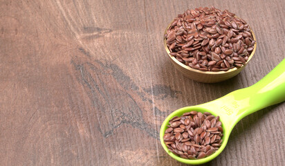 Brown flax seed or linseed on wooden background. Diet healthcare healthy food.

