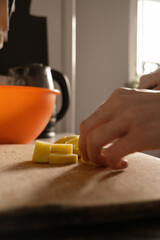 Cooking. Close-up of a kitchen knife in female hands. A woman cuts vegetables for soup. A knife cuts potatoes on a wooden board