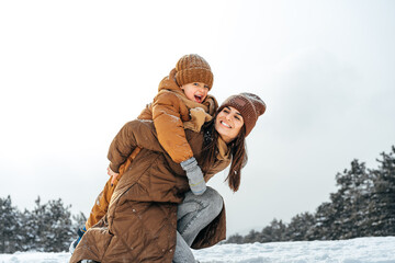 Woman with a little son on a winter hike in the snowy forest