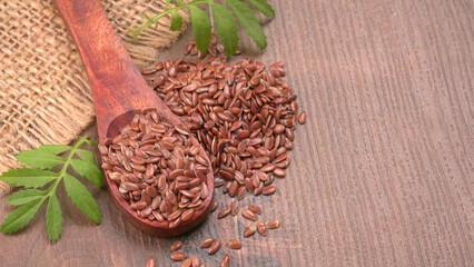 Brown flax seed or linseed on wooden background. Diet healthcare healthy food.