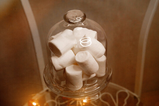 marshmallows in a glass bowl on a concrete background