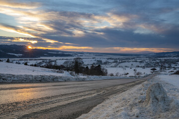 mountain road in snowy winter during a magnificent sunset