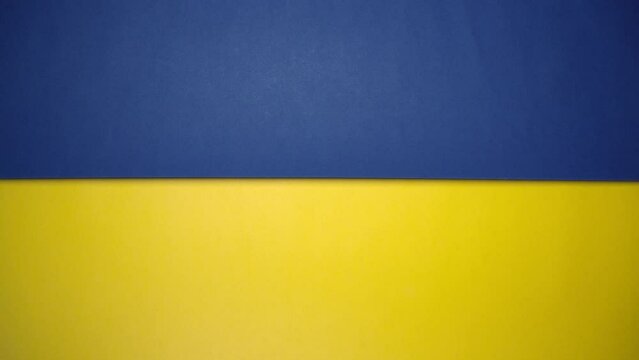 Blue and yellow paper rolling on green screen. Blue and yellow are colors of Ukraine national flag.