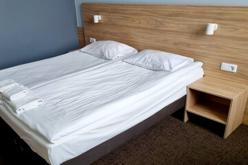 View of the modern bed with white bedding.