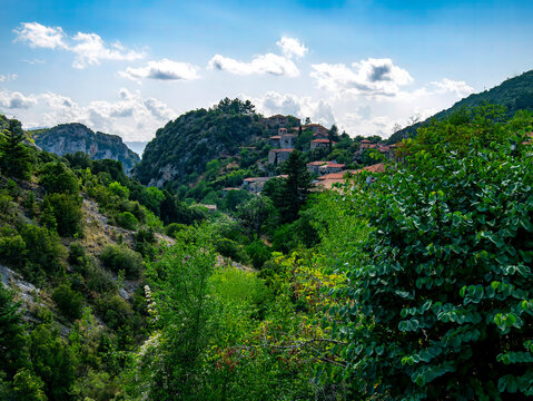 Sunny day over stone houses with tile roofs on Arcadia's rocky, yet green mountains