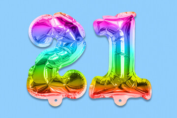 Rainbow foil balloon number, digit twenty one on a blue background. Birthday greeting card with inscription 21. Top view. Numerical digit. Celebration event, template.