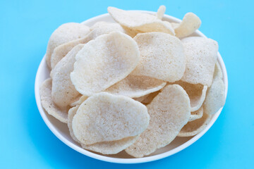 Prawn crackers on blue background. Shrimp crispy rice snack