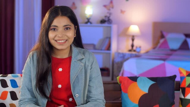 A beautiful teenage girl with long black hair smiling while looking at the camera - posing a modern lifestyle photogenic. A sweet girl in casual clothes relaxing on a comfortable sofa at home - l...