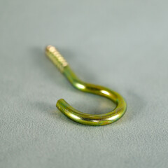 Yellow python screw. Screw with hook-shaped back. Focus is on the front.