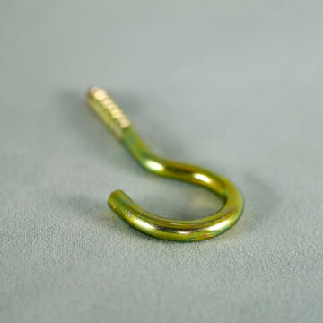 Yellow python screw. Screw with hook-shaped back. Focus is on the front.